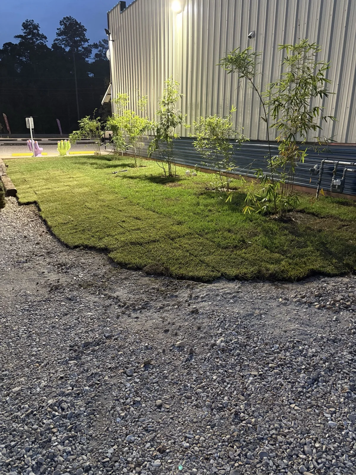 Finished grade with new sod and gravel along a metal commercial building near Hammond, LA