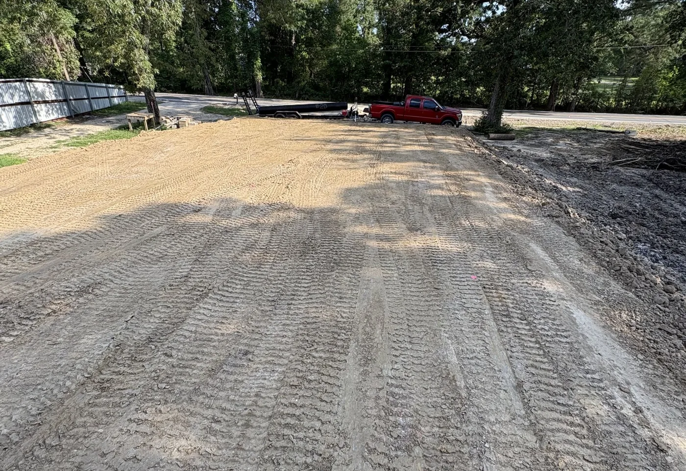 Freshly graded gravel driveway running between trees on a lot near Hammond, LA