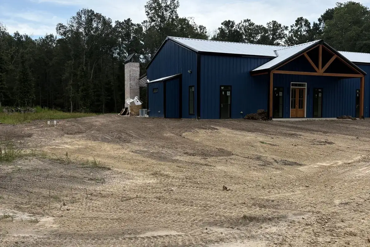 Graded dirt lot in front of a blue metal building near Hammond, LA